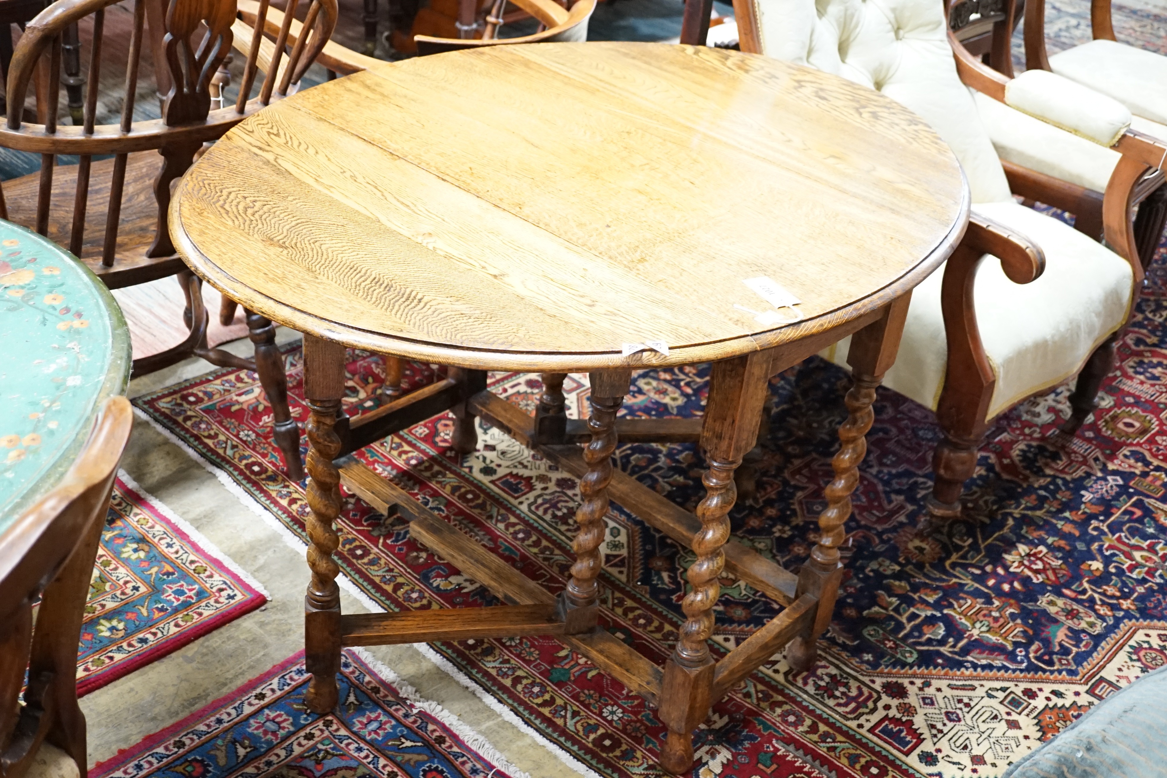 A 1920's oak gateleg table opens to 117 x 90cm and an Edwardian carved oak folding occasional table, width 45cm